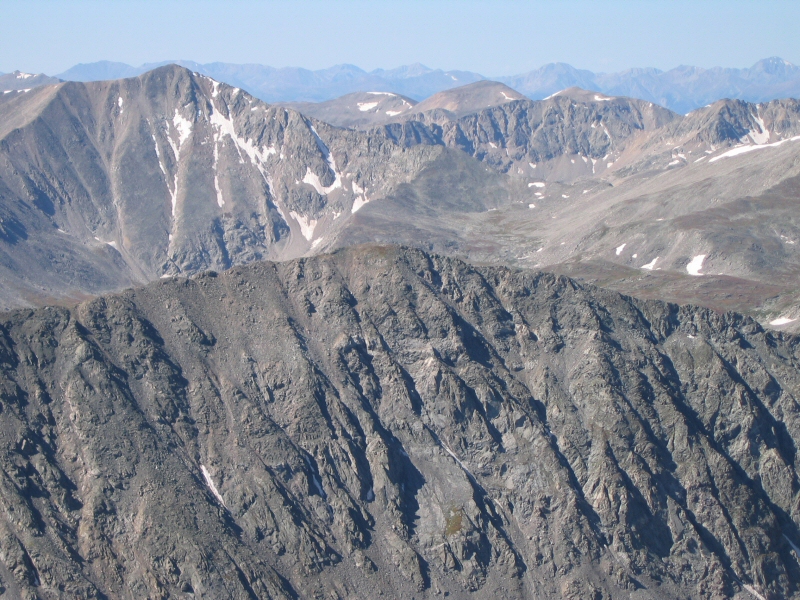 From left to right, a closer shot of Mount Buckskin, a distant Treasurevault Mountain, no-name summit (at 13,672 feet).  On the horizon is La Plata Peak to the right, and other mountains in the Collegiate Peaks Range to the left.