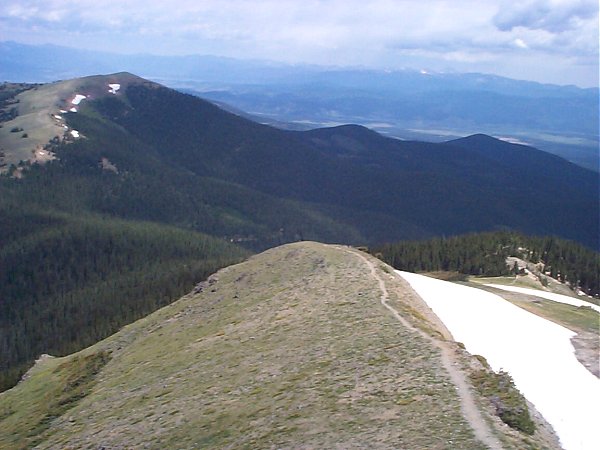 A view of the trail as it follows the ridge back down.  [Note: if you click through to the larger image you may be able to notice the road to the trailhead hidden in the trees just to the left of the knob near the middle of the image.]