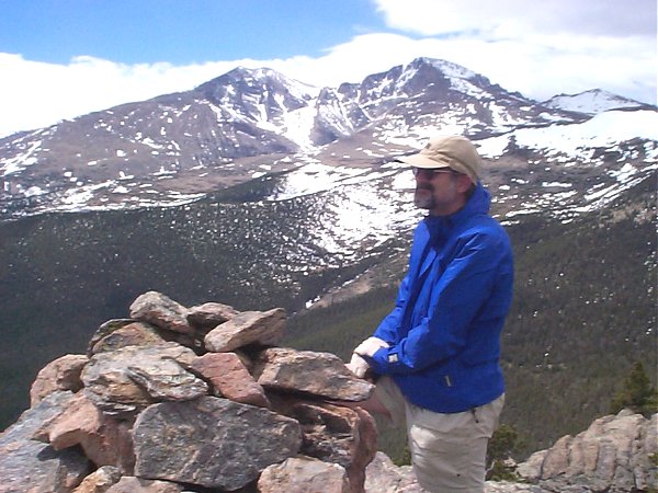 Mike on the summit admiring the view of the Twin Sisters with Long's Peak in the background.