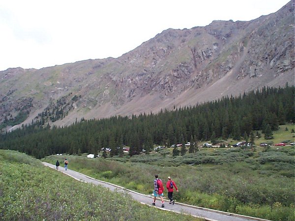 Multitudes of cars and people as seen while looking back towards the parking lot and trailhead for Grays and Torreys Peak (and Kelso Mountain).