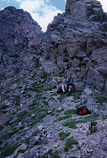 Sitting on the rocks beside the saddle.