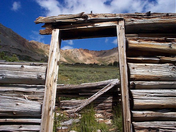 Looking north up the valley through the ruins of an old mining shack.