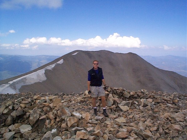 Steve posing on the summit of East Mount Sopris with West Mount Sopris in the background.